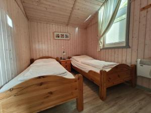 twee eenpersoonsbedden in een kamer met een raam bij Ferienhaus im skandinavischen Stil in Rechlin
