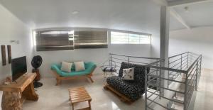 un soggiorno con scala e sedia verde di Paulas place a Garzón