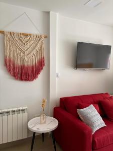 a living room with a red couch and a tv at Gente del Sur - Avenida in Ushuaia