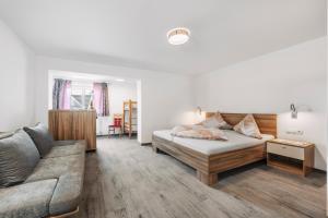 ein Wohnzimmer mit einem Bett und einer Couch in der Unterkunft MonteVita Pitztal Panorama Apartments 