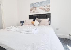 a bedroom with a white bed with towels on it at Stylish & Modern 2BR Flat nr Nottingham City Centre in Nottingham