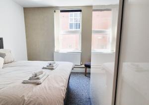 a bedroom with a bed with towels on it at Stylish & Modern 2BR Flat nr Nottingham City Centre in Nottingham +26 photos