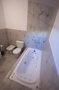 een badkamer met een wit bad en een toilet bij Casa Boutique Los Molles in Villa Las Rosas