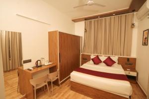 a hotel room with a bed and a desk at The Lawrences Aqua Stay in Cochin