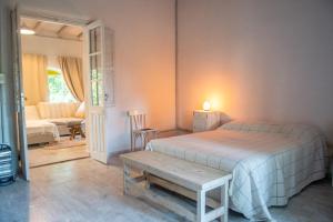 een slaapkamer met een bed, een tafel en een bank bij Casa Boutique Los Molles in Villa Las Rosas