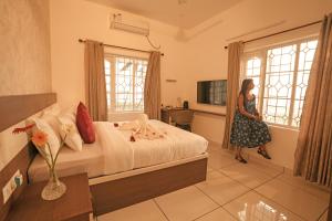 a woman is standing in a hotel room at The Lawrences Aqua Stay in Cochin +20 photos