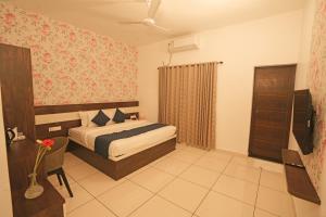 a bedroom with a bed and a chair in it at The Lawrences Aqua Stay in Cochin
