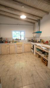 een grote keuken met houten kasten en een tegelvloer bij Casa Boutique Los Molles in Villa Las Rosas