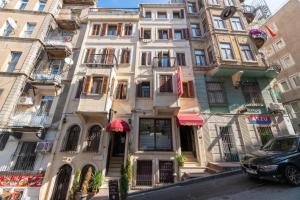 a building on a street with a car parked in front at Taksim full House in Istanbul