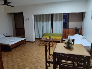 a hotel room with two beds and a table and chairs at Residencial P&P in Mindelo +24 photos