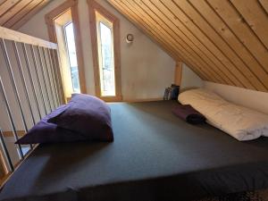 Yukon Sweet Spot Bed and Bakery في وايتهورس: غرفة مع وسادتين على سرير في العلية