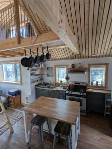 Yukon Sweet Spot Bed and Bakery في وايتهورس: مطبخ مع طاولة خشبية وموقد