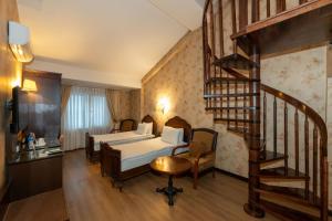 a bedroom with a bed and a spiral staircase at Taksim Pera Rose Hotel & Spa - Istiklal Street in Istanbul +67 photos