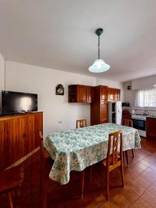 een keuken met een eettafel met stoelen en een televisie bij Casa Surf bonnet in Mar del Plata
