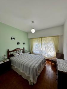 een slaapkamer met een groot bed en een groot raam bij Casa Surf bonnet in Mar del Plata +14 foto's