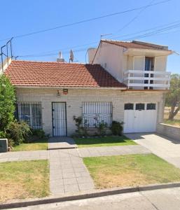 een wit huis met een rood dak bij Casa Surf bonnet in Mar del Plata