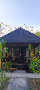 吉利美诺AMIGOS BUNGALOWS GILI MENO的一栋黑色屋顶的小房子 更多30张照片