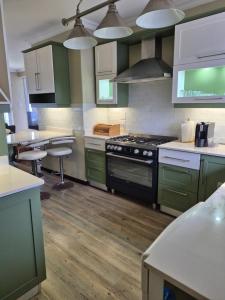 a kitchen with green cabinets and a stove at Jakaranda Holiday Flat in Uvongo Beach