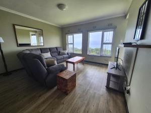 a living room with a couch and a table at Jakaranda Holiday Flat in Uvongo Beach