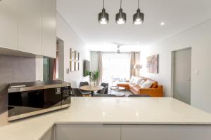 a kitchen with a counter top and a living room at York Escape - Townhouse 26 in George