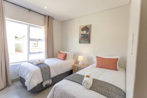 York Escape - Townhouse 26 في جورج: سريرين في غرفة بها نافذة