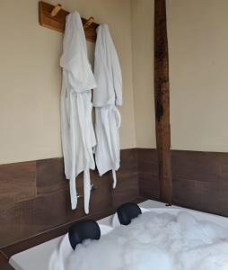 a bedroom with white robes hanging on a wall at Recanto dos Canários - CHALÉ 1 in Visconde De Maua