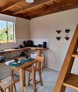 a kitchen with a wooden table and chairs at Recanto dos Canários - CHALÉ 1 in Visconde De Maua