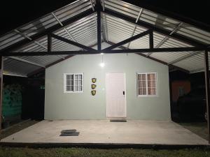 a garage with a white wall and a pink door at Casa Colibrí, entera, Volcán in Volcán