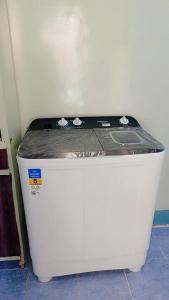 biała chłodziarka siedząca na podłodze w pokoju w obiekcie شقه بنزله عبد اللاه باسيوط w mieście Nazlat ‘Abd Allāh