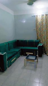 salon z zieloną kanapą i stołem w obiekcie شقه بنزله عبد اللاه باسيوط w mieście Nazlat ‘Abd Allāh