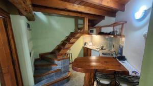 a kitchen with a wooden table and a staircase at Casa Del Bosque Aparts in Villa La Angostura