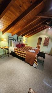 a bedroom with a large bed with a wooden ceiling at Casa Del Bosque Aparts in Villa La Angostura +57 photos