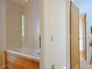 a bathroom with a bath tub with a window at 6 Stonerush Valley in Looe +37 photos