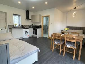 een keuken en een woonkamer met een bed en een tafel bij Daisy in Northampton