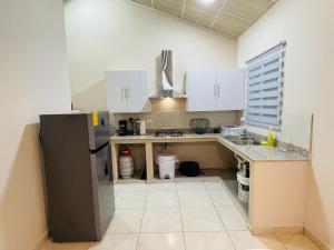 a kitchen with white cabinets and a stainless steel refrigerator at Casa Colibrí, entera, Volcán in Volcán