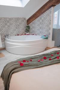 ein Badezimmer mit einer Badewanne mit roten Rosen auf dem Boden in der Unterkunft Le Nid vue et détente à St Etienne in Saint-Étienne