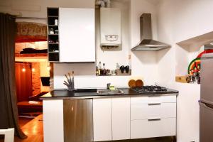 una cucina con mobili bianchi e un lavandino di Penthouse in central Milan a Milano