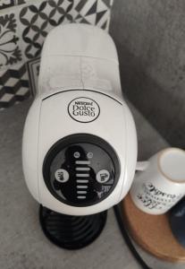 Nahaufnahme eines Haartrockners neben einer Tasse in der Unterkunft Le Nid vue et détente à St Etienne in Saint-Étienne