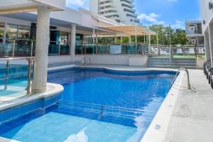 a swimming pool in front of a building at Hotel Arhuaco Rodadero in Santa Marta +82 photos