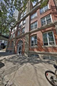 a building on a street with a bike in front of it at Ice District 2 Kings Private Parking Patio in Edmonton
