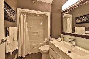 a bathroom with a toilet and a sink and a shower at Ice District 2 Kings Private Parking Patio in Edmonton +13 photos