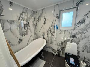 Un baño con bañera y ventana. en Family & Worker Accommodations in Uddevalla, en Uddevalla