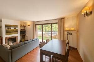 un salon avec un canapé et une table dans l'établissement Vall Fosca - Apartamento con espectaculares vistas y jardín privado, à Torre de Capdella