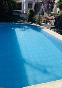 une grande piscine bleue devant une maison dans l'établissement Casa Allende, à Córdoba
