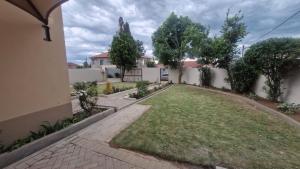 a backyard of a house with a yard at Nkwe Guesthouse in Roodepoort
