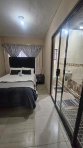 a bedroom with a bed and a view of a bathroom at Nkwe Guesthouse in Roodepoort
