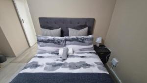 a bed with a blue and white comforter and pillows at Nkwe Guesthouse in Roodepoort