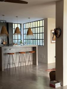 eine Küche mit einer Bar mit Hockern und Fenstern in der Unterkunft Stylish Loft with Nature Views, Balcony in the heart of Vejer in Vejer de la Frontera + 27 Fotos
