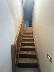 una scala in una stanza vuota con gradini in legno di La casa di Artu a Passoscuro