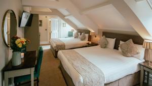 ディングルにあるAdams Townhouseのベッド2台と机があるホテルの部屋